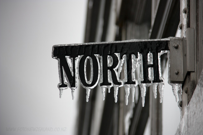 Указатель севера на Эмпайр Стейт Билдинг покрытый льдом