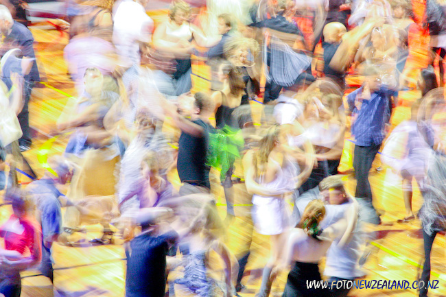 Размытые в движении силуэты людей на танцевальном полу